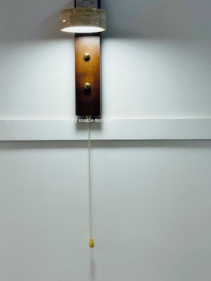 En vægmonteret lampe med træfod og hængende pendel.