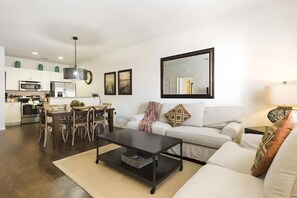 Ein modernes Wohnzimmer mit einer Couch, einem Couchtisch und einem Essbereich.