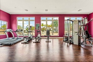 A gym with treadmills, elliptical machines, and weight equipment. - Amazing 4bdr House Near Disney (Kissimmee)