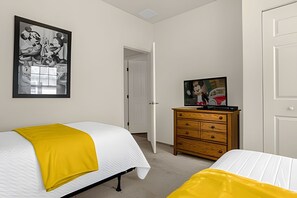 A bedroom with two beds, a wooden dresser, a television, and a framed picture on the wall. - 4BR Lucaya Village Home, Sleeps 10 (Kissimmee)