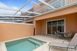 A rooftop pool area with a glass balustrade, outdoor seating, and a sliding glass door. - 3BR Serenity Townhome Near Disney (Clermont)