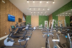 A gym with treadmills, stationary bikes, and weight machines. - 3BR Magic Village Townhome Near Disney (Kissimmee)