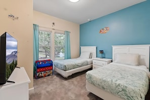 A bedroom with two beds, a TV, a window with curtains, and a dresser. - 4BR Gated Home Near Disney, Sleeps 10 (Kissimmee)