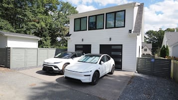 Ein modernes, zweistöckiges Haus mit Garage, zwei weiße Autos vor der Tür und einem gepflegten Einfahrt.