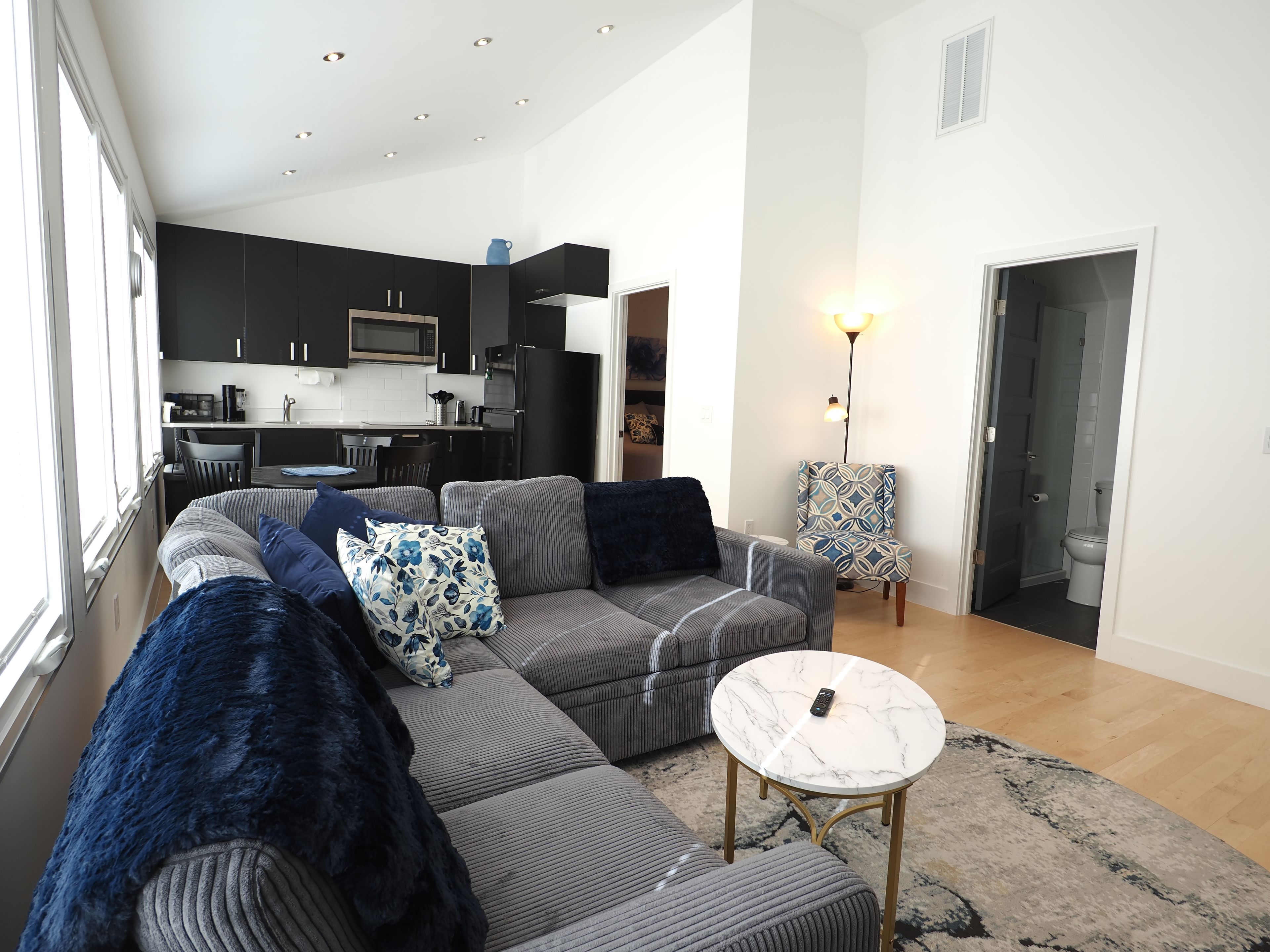 A modern living room with a sofa, a coffee table, and a patterned armchair.