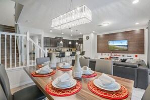 A modern kitchen with dark cabinets, a stainless steel refrigerator, and a microwave. - 5BR Home Near Disney With Clubhouse (Kissimmee)