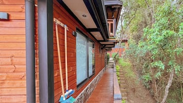 A wooden building with a covered walkway and a view of a forested area.