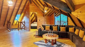 A cozy attic room with a wooden ceiling, a sofa set, and a round coffee table. - Vrbo Property (Antioquia)