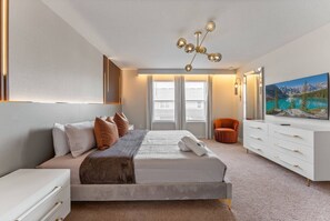 A modern bedroom with a large bed, a white dresser, and a painting of a mountain landscape. - 5BR Villa w/ Pool, Themed Rooms Windsor Island (Davenport)