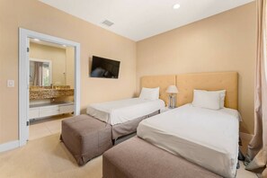 A hotel room with two beds, a TV, a bathroom with a mirror, and a beige color scheme. - Disneyarea 4BR Villa w/ BBQ Balconies & Parking (Kissimmee)