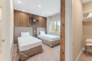 A bedroom with two beds, wooden paneling on the wall, a clock, and a window with curtains. - Magic Vilage Cozy Attractive 8min Disney (Kissimmee)