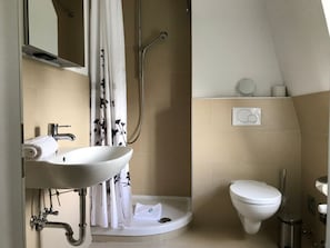 A bathroom with a sink, toilet, shower, and a towel rack. - "villa Friedericia" - Apt. 04 (Wyk auf Foehr)