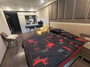 A modern bedroom with a large bed, a desk, and a chair. - Vrbo Property (Batumi)