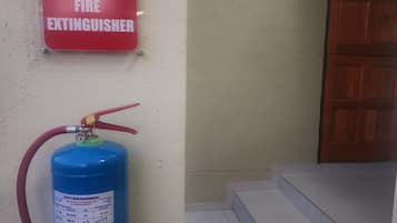 A fire extinguisher mounted on a wall with a red sign above it.