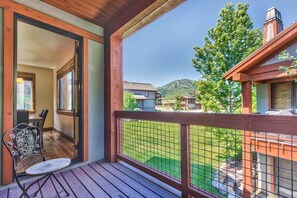 A wooden deck with a metal railing, a chair, and a view of a mountain landscape. - Luxury Pet Friendly 4-bed PC Ski & Lake House (Wasatch County)