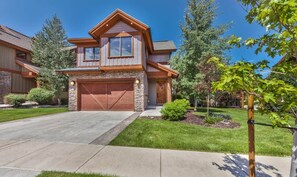 A two-story house with a stone facade, a garage, and a well-maintained lawn. - Luxury Pet Friendly 4-bed PC Ski & Lake House (Wasatch County)