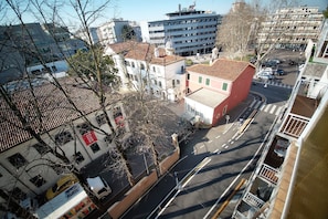 A multi-story building with a red facade, a courtyard, and a street view. - Sunlit-balcony (Mestre)