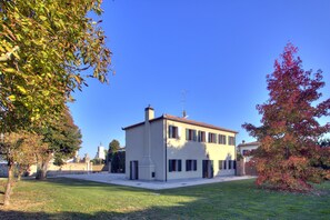 A two-story building with a flat roof, a chimney, and a small tower-like structure on the roof. - Torre~barbariga Country House (Stra)