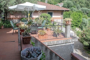 A patio with outdoor furniture, potted plants, and a white umbrella. - Alassio-villa-sea-view (Alassio)