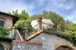 A stone staircase with a metal railing, leading to a covered area with a white canopy. - Alassio-villa-sea-view (Alassio)