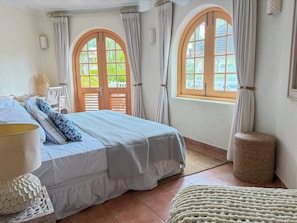 A bedroom with a bed, curtains, a window, and a woven basket. - Palm Breeze Villa – Private Pool, Beach Club Access & Sugar Hill Resort (Porters)