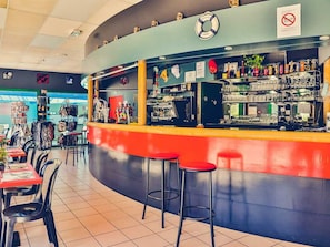 Eine Bar mit Hockern, einer Theke und verschiedenen Ausstellungsstücken.