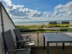 A balcony with a table and chairs overlooking a beach. - "haus Parkstrasse" - Apt. 07 (Wyk auf Foehr)