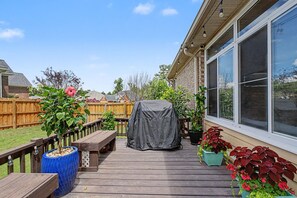 A wooden deck with a covered grill, potted plants, and a wooden fence. - 5BR Masters Retreat ~ 10 min to Augusta National (Martinez)