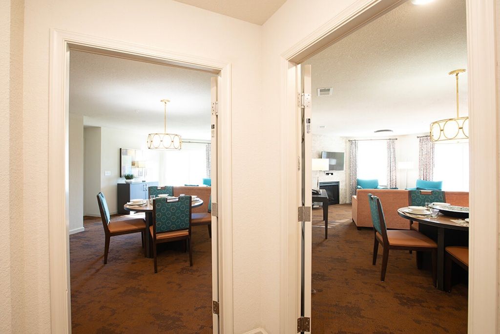 A hotel room with a dining area, a kitchen, and a living space.