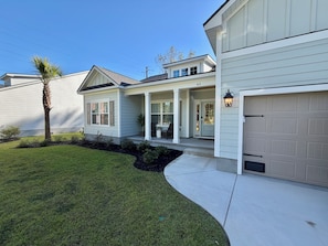 A residential property with a covered porch, a garage, and a well-maintained lawn. - Wonderful 4-bedroom house in adorable Pawleys Island (Pawleys Island)