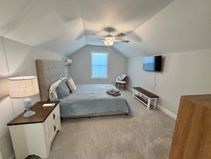 A bedroom with a bed, bedside table, lamp, TV, and a ceiling fan. - Wonderful 4-bedroom house in adorable Pawleys Island (Pawleys Island)