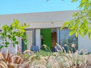 A modern building with a green interior, large windows, and a view of the surrounding vegetation. - Suite Smaragd Luxury Accommodation (Olhao)