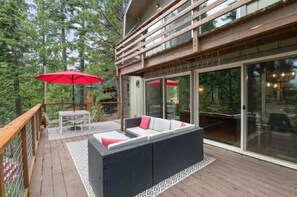A wooden deck with outdoor furniture and a glass door leading to an interior space. - Tahoe Retreat with Hot Tub in Carnelian Bay (Carnelian Bay)