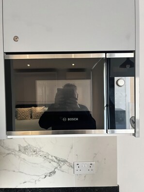 Keittiössä on Bosch-merkkinen jääkaappi, marmorinen työtaso ja pistorasia.
