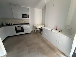A compact kitchen with a built-in oven, microwave, and white cabinetry. - Short Stay Experts A3 - E1 Studio  8 floor apartment (Gibraltar)