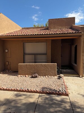 A residential building with a tiled roof, a garage door, and a paved driveway. - Modern 3-bedroom & 2-bathroom townhome in Phoenix (Phoenix)