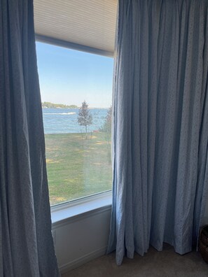 A room with a large window, curtains, and a view of a grassy area and water. - Spacious 3-bedroom house in beautiful Montgomery with AC (Montgomery)