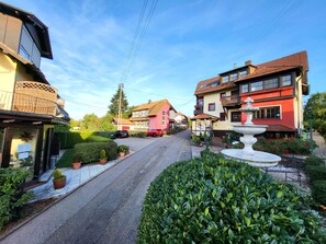 A street view with houses, a fountain, and potted plants. - Landhotel Schönblick Group House for up to 47 people (Bad Herrenalb-Rotensol)