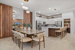 A modern kitchen with a central island, white cabinetry, and stainless steel appliances. - A New 9BR to Relax in Orlando in Style (2584SN) (Kissimmee)