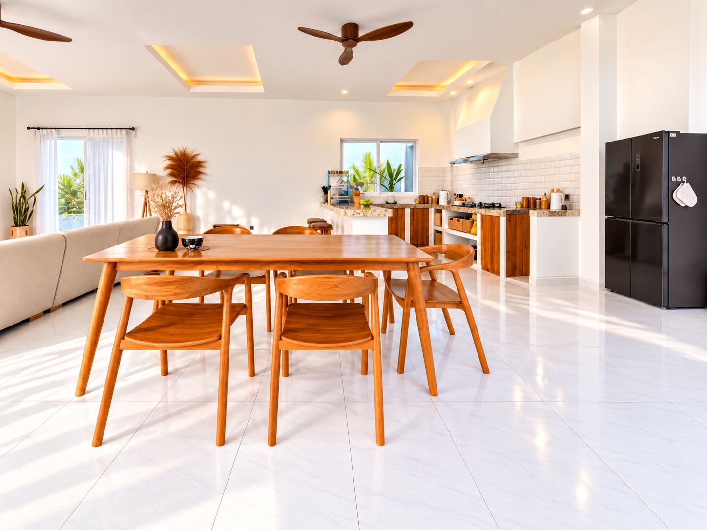 A modern kitchen with a dining area, featuring a black refrigerator, wooden chairs, and a ceiling fan.