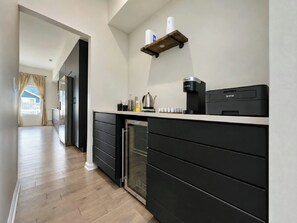 A modern kitchen with a built-in dishwasher, a coffee maker, and a small refrigerator. - Fountain Square 3BR 2 Kings Sleeps 8 (Indianapolis)
