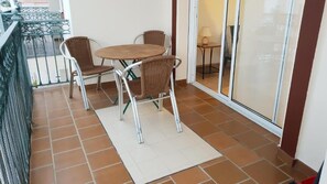 A balcony with a table and chairs, a tiled floor, and a view of the outside. - 2A Apartamentos Latin (Nerja)