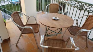A balcony with a round table and four wicker chairs. - 2A Apartamentos Latin SilHouse Nerja (Nerja)