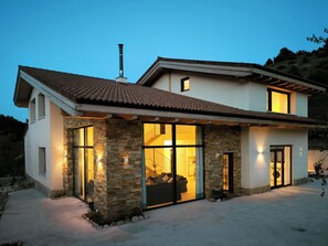 A two-story house with a stone facade, large windows, and a tiled roof. - The perfect home for families and friends! In a peaceful, natural setting. (Prádena)