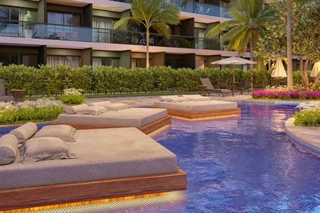 Un área de piscina con sillones de descanso y una fuente de agua.