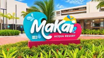Señal para el Resort Makai Acqua, con un edificio moderno al fondo.