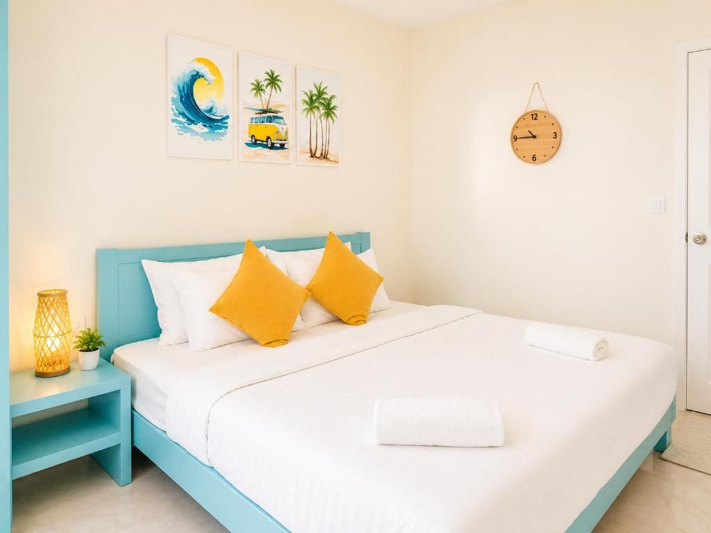 A bedroom with a bed, a nightstand, a wall clock, and artwork.