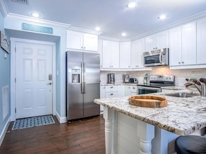 A modern kitchen with white cabinetry, stainless steel appliances, a marble countertop, and a built-in oven. - Coco Plum Beach Paradise 1 bedroom apt, great view, boat slip (Marathon)