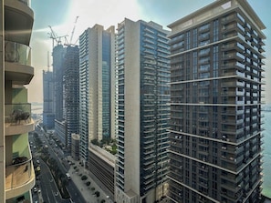 A high-rise residential building with multiple balconies, a modern architectural design, and a view of the surrounding urban area. - Sea & Marina View 2BR | Private Beach & Pool (Dubai)