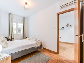 A bedroom with a bed, bedside table, and a window with curtains. - Renovated Apartment Near Gran Via (Madrid)